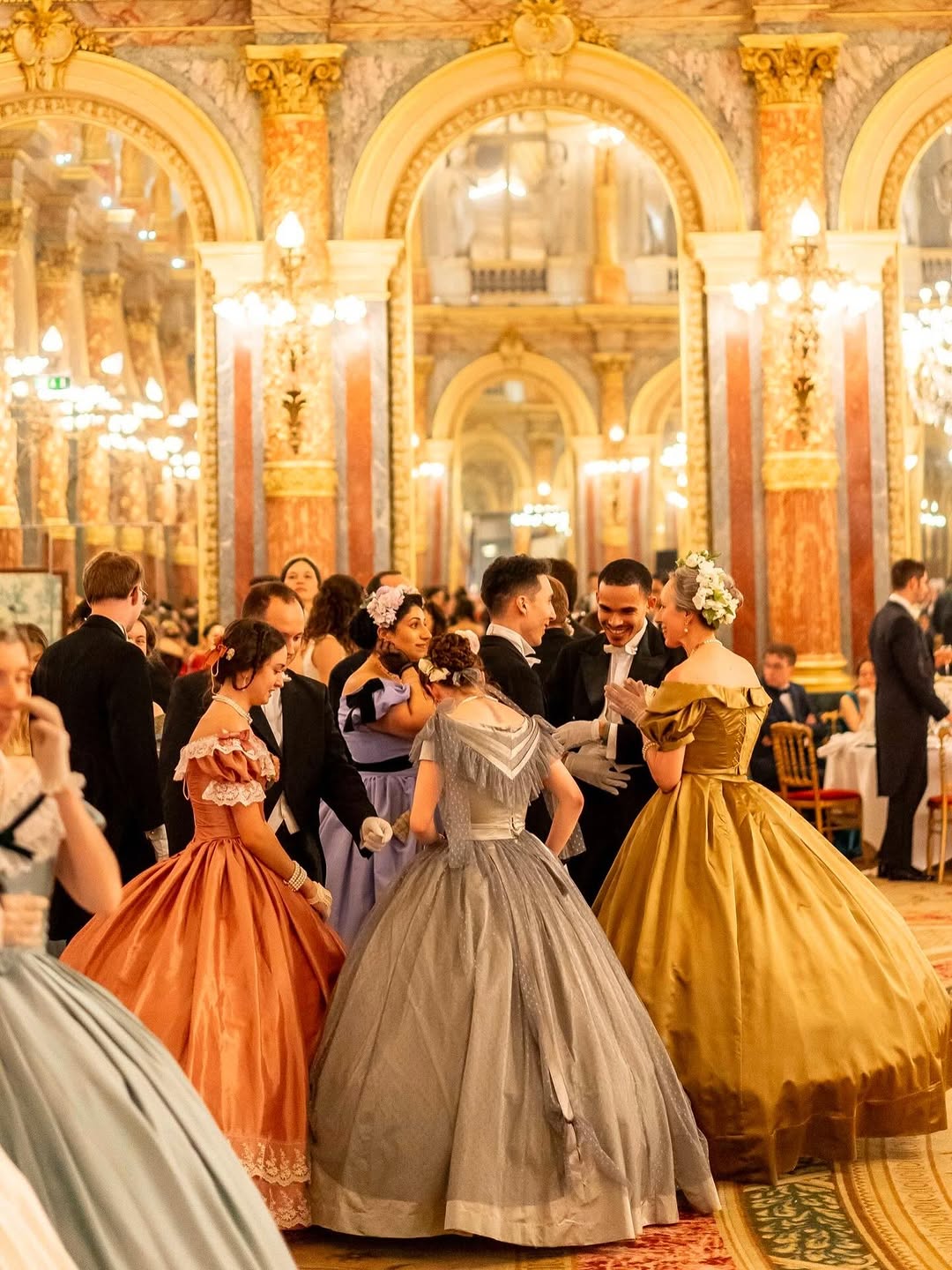 Danseuses et danseurs en costume historique réunis dans un salon de bal