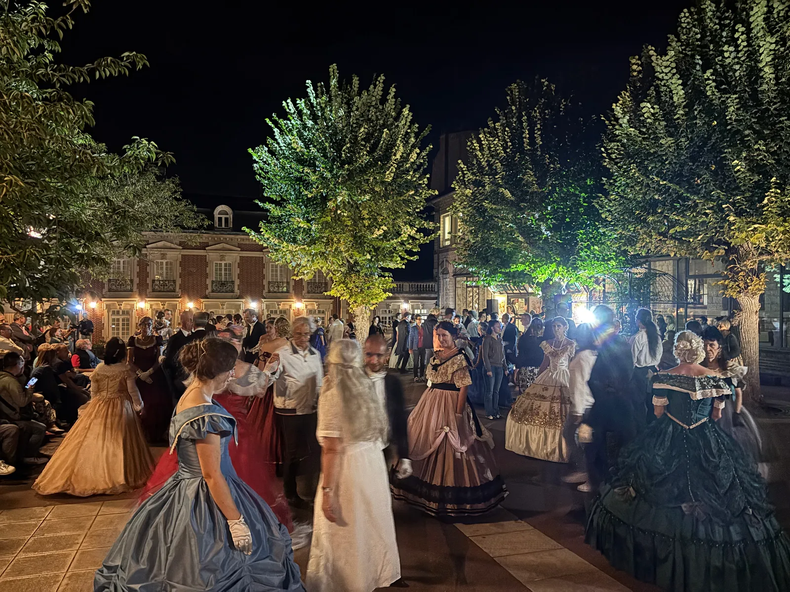 Danseurs en costumes du Second Empire dans la cour éclairée du Musée de la Dentelle