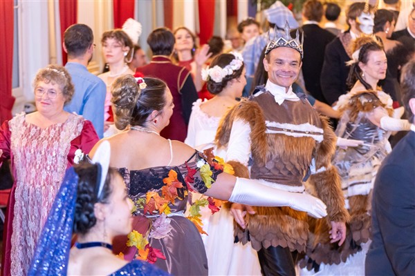 Des invités costumés dansent ensemble dans un salon