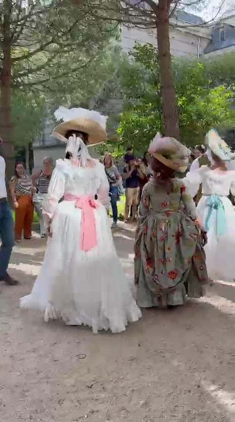 Danseuses en costumes baroques exécutant une figure devant le public dans les jardins