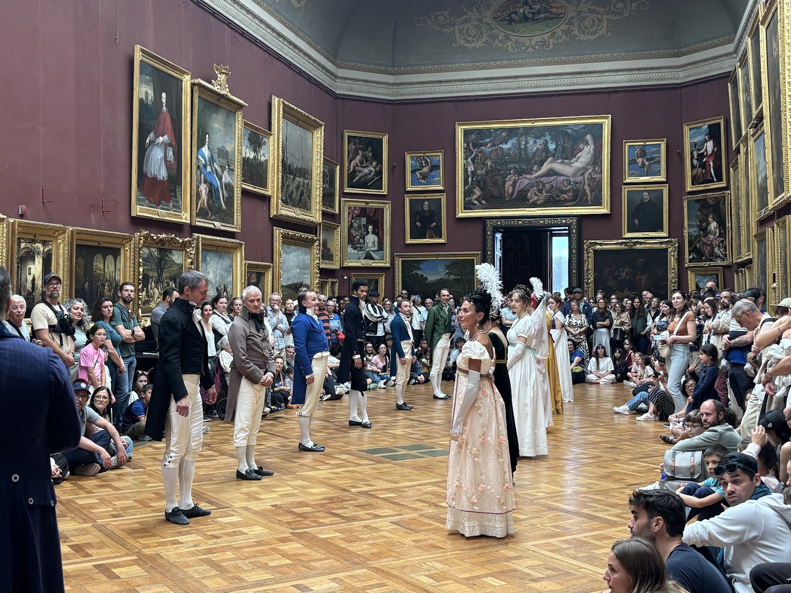 Démonstration de danse en costumes Premier Empire entourée de spectateurs dans la galerie des portraits