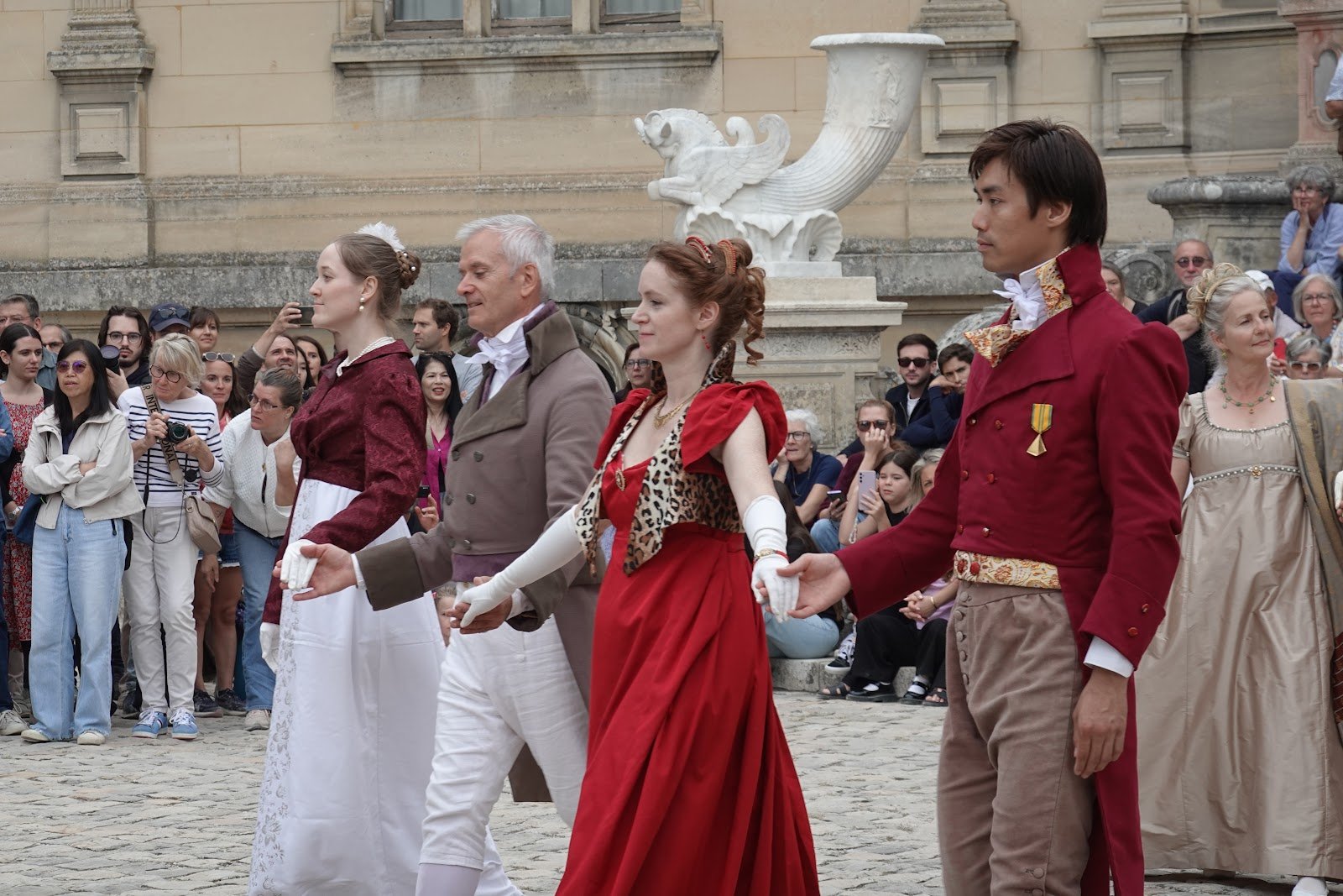 Danseuses et danseurs se tenant par la main pendant une démonstration dans la cour