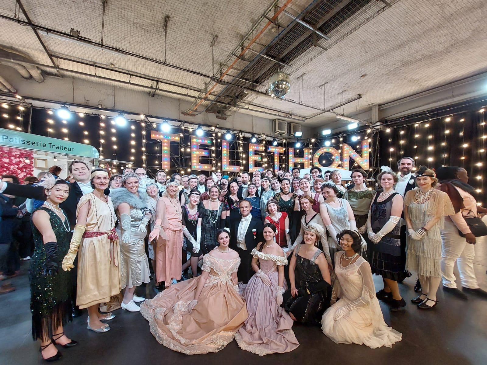 Les participants de Carnet de Bals en costumes devant le décor du Téléthon